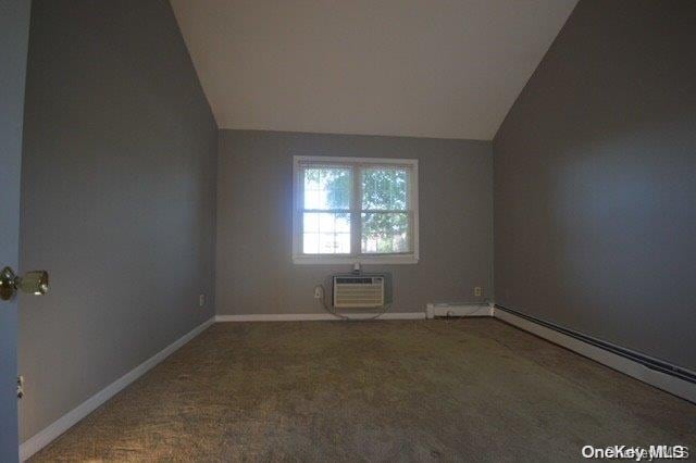 spare room with carpet flooring, a wall mounted AC, and lofted ceiling