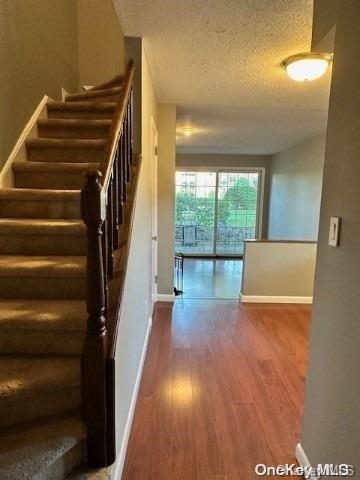 stairs featuring hardwood / wood-style flooring and a textured ceiling