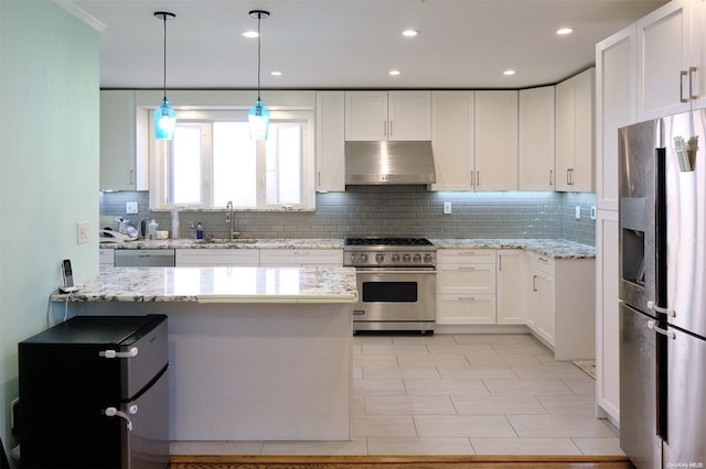 kitchen featuring white cabinets, extractor fan, backsplash, and appliances with stainless steel finishes