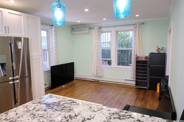 interior space with white cabinetry, an AC wall unit, stainless steel fridge, hardwood / wood-style floors, and decorative light fixtures