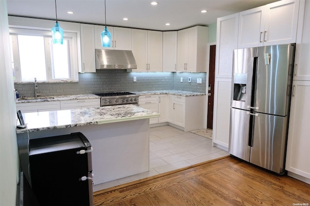 kitchen featuring light wood-type flooring, ventilation hood, stainless steel appliances, sink, and white cabinetry