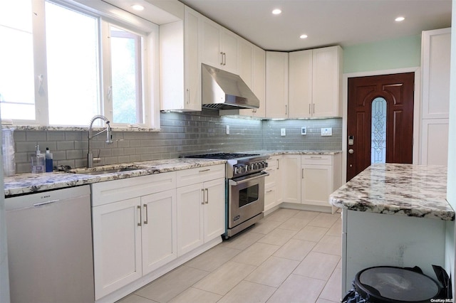 kitchen featuring white cabinetry, sink, stainless steel appliances, light stone counters, and extractor fan