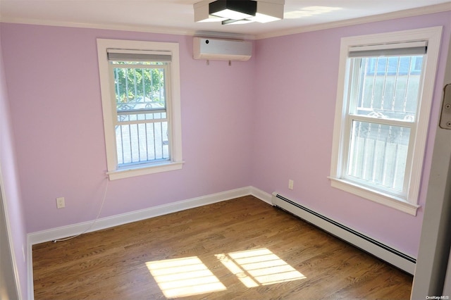 spare room featuring hardwood / wood-style floors, a wall unit AC, baseboard heating, and crown molding