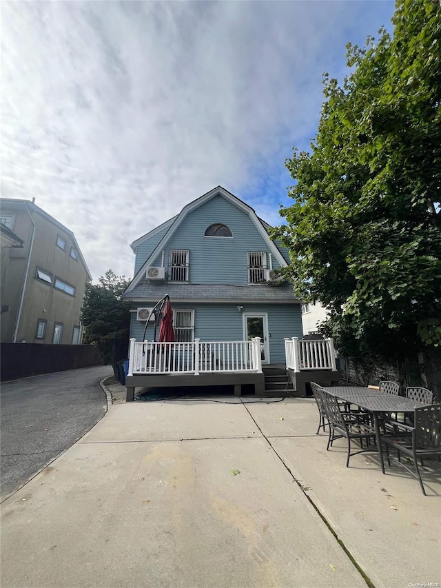 rear view of property with a patio and a wooden deck