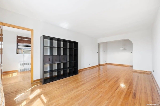 unfurnished room with hardwood / wood-style flooring and radiator