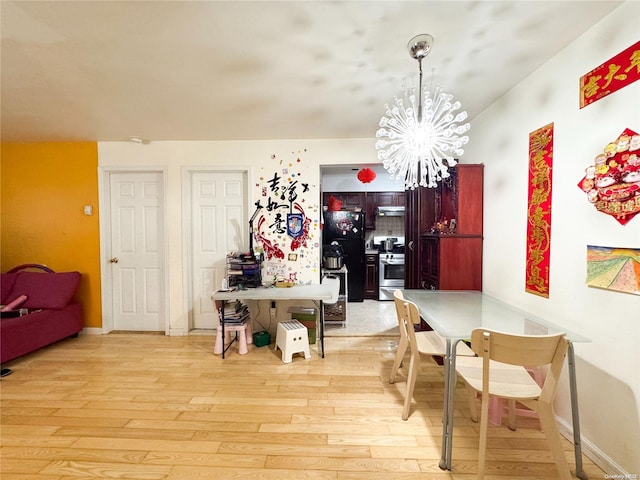 dining area with an inviting chandelier and light hardwood / wood-style flooring