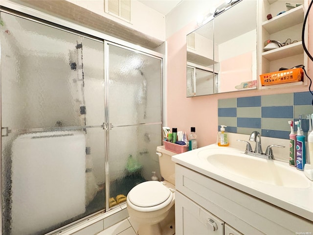 bathroom featuring backsplash, an enclosed shower, vanity, tile patterned flooring, and toilet