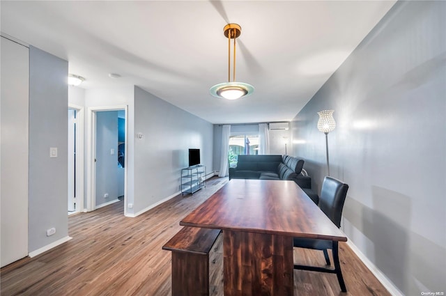 unfurnished dining area with hardwood / wood-style flooring and a wall mounted AC