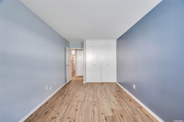 unfurnished bedroom with light hardwood / wood-style floors and a closet