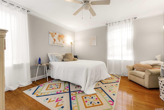 bedroom featuring ceiling fan, ornamental molding, and hardwood / wood-style flooring