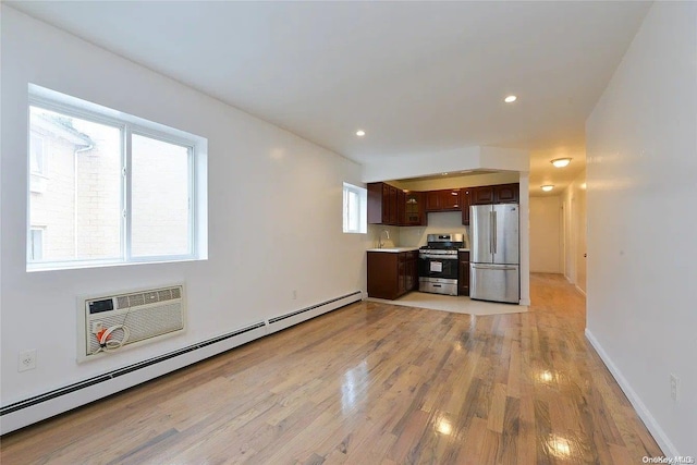 197-21 Carpenter Ave Unit 2G, Jamaica, NY 11423 - kitchen featuring a wall mounted air conditioner, light wood-type flooring, dark brown cabinets, stainless steel appliances, and a baseboard radiator