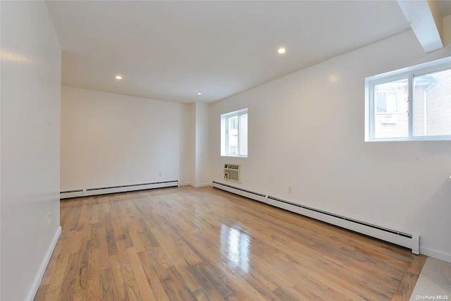 197-21 Carpenter Ave Unit 2G, Jamaica, NY 11423 - empty room with a baseboard radiator, a wall mounted AC, and light hardwood / wood-style floors