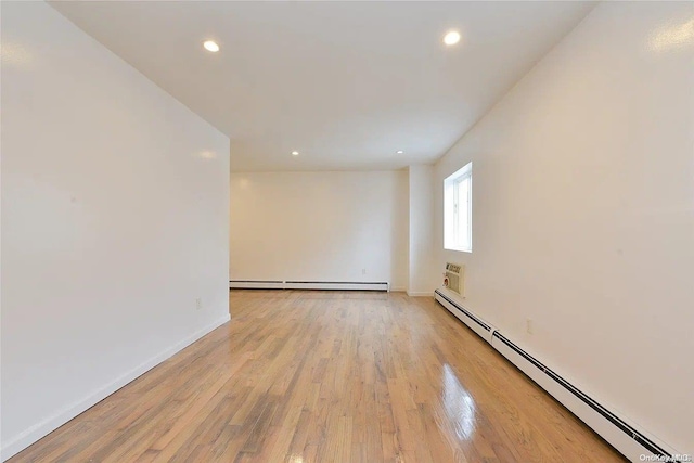 spare room featuring a baseboard radiator and light wood-type flooring