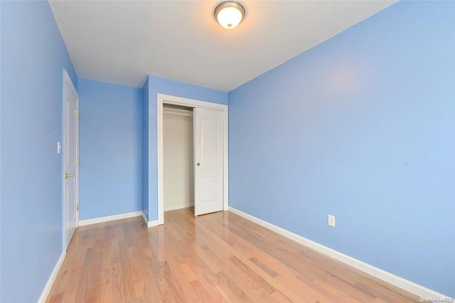 unfurnished bedroom with a closet and light hardwood / wood-style flooring