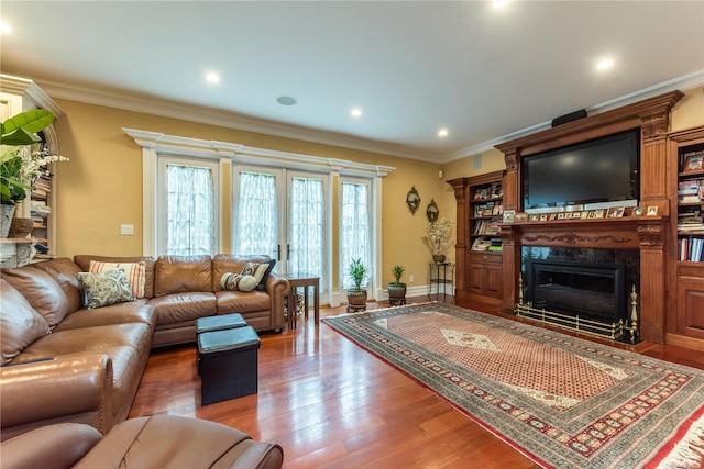 living room featuring a high end fireplace, wood-type flooring, and crown molding