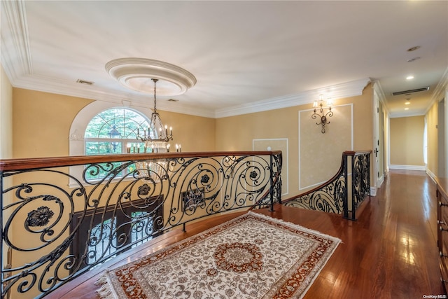 corridor featuring dark hardwood / wood-style flooring, crown molding, and an inviting chandelier