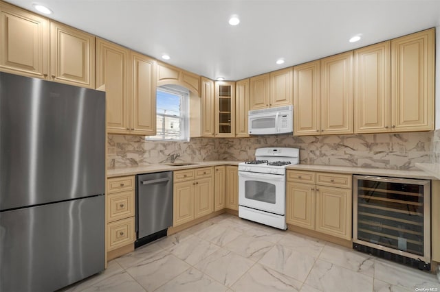 kitchen featuring sink, light brown cabinetry, tasteful backsplash, stainless steel appliances, and beverage cooler