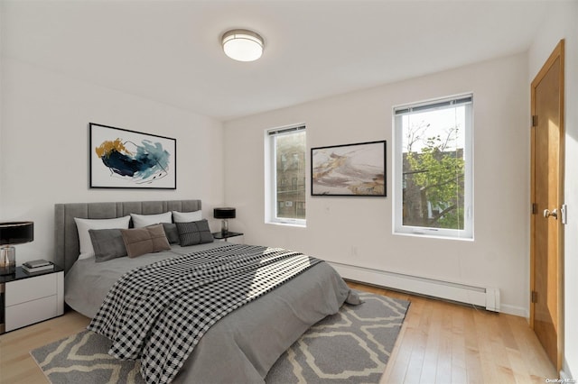 bedroom featuring light wood-type flooring and a baseboard radiator