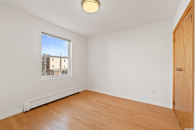 spare room with light hardwood / wood-style floors and baseboard heating