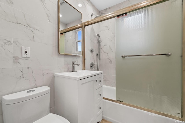 full bathroom with vanity, enclosed tub / shower combo, tile walls, and toilet