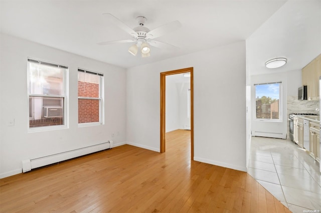 unfurnished room featuring ceiling fan, light wood-type flooring, and baseboard heating