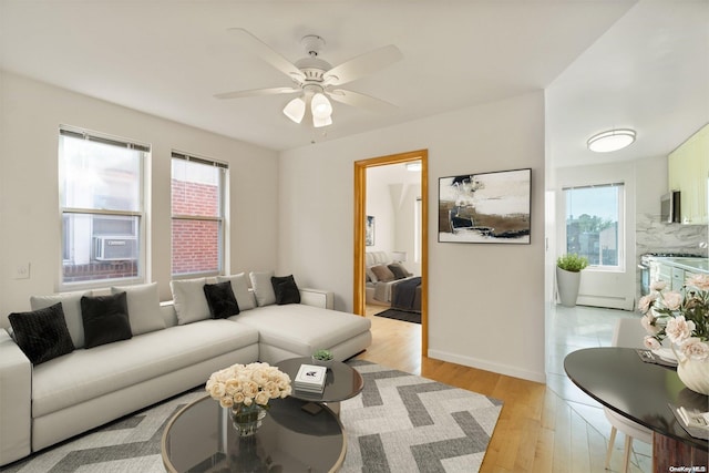 living room with ceiling fan and light hardwood / wood-style flooring