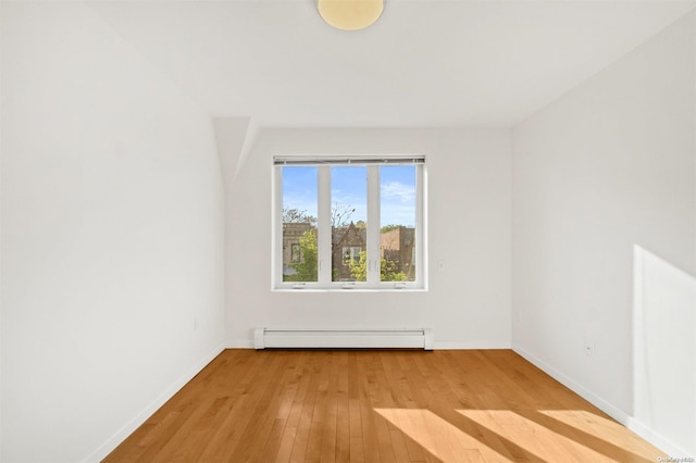 spare room featuring light hardwood / wood-style floors and a baseboard heating unit