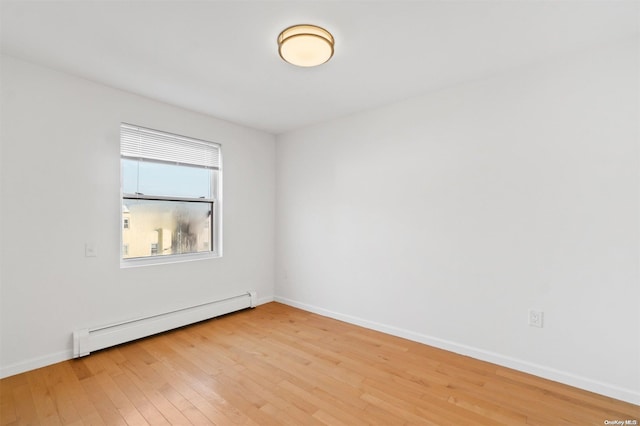 spare room with wood-type flooring and baseboard heating