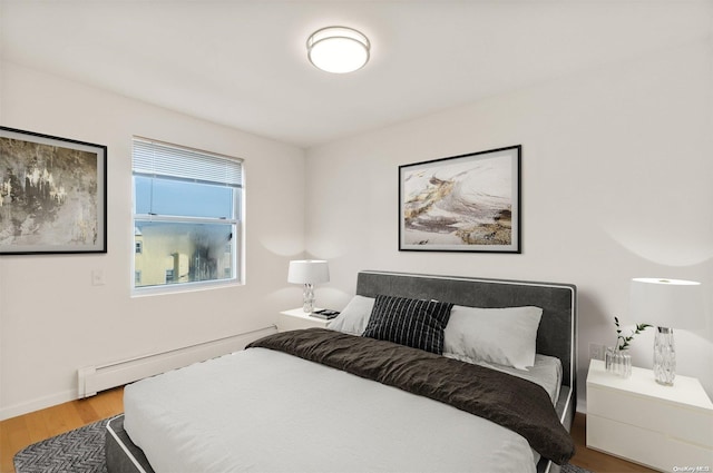 bedroom featuring hardwood / wood-style flooring and a baseboard radiator