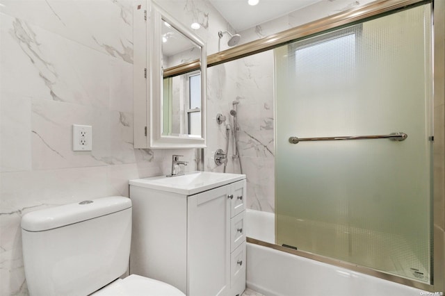 full bathroom with toilet, vanity, tile walls, and combined bath / shower with glass door