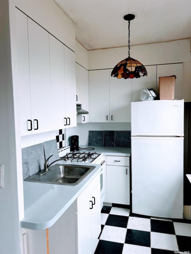 kitchen featuring pendant lighting, white refrigerator, sink, white cabinetry, and extractor fan