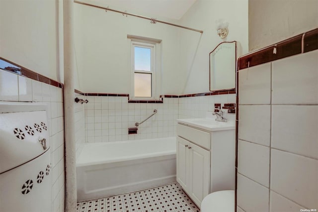 bathroom with a tub to relax in, vanity, tile walls, and toilet