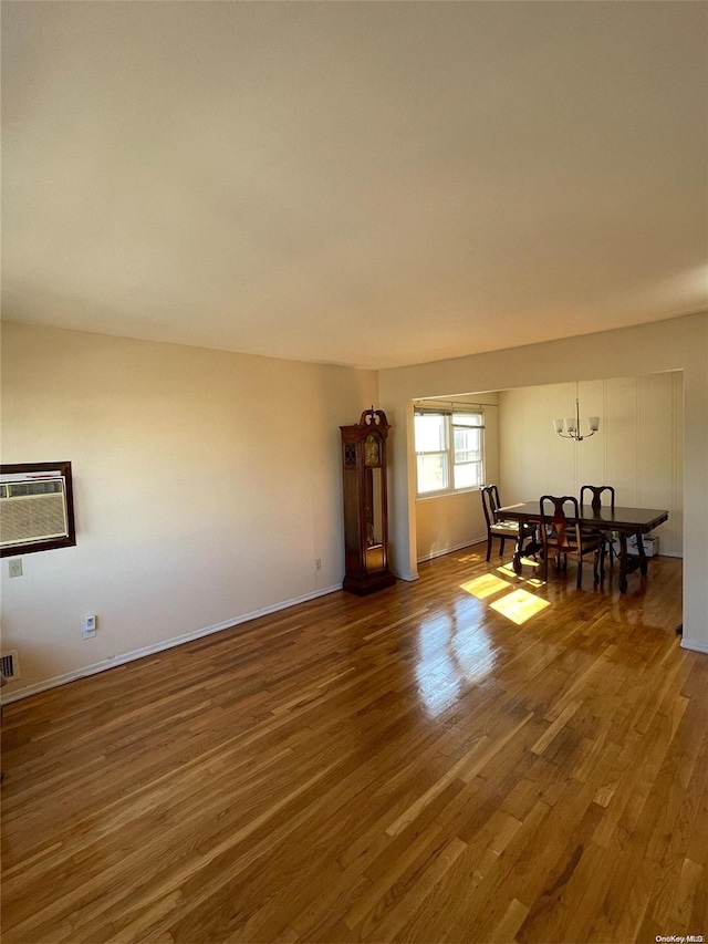 interior space with an inviting chandelier, an AC wall unit, and dark wood-type flooring