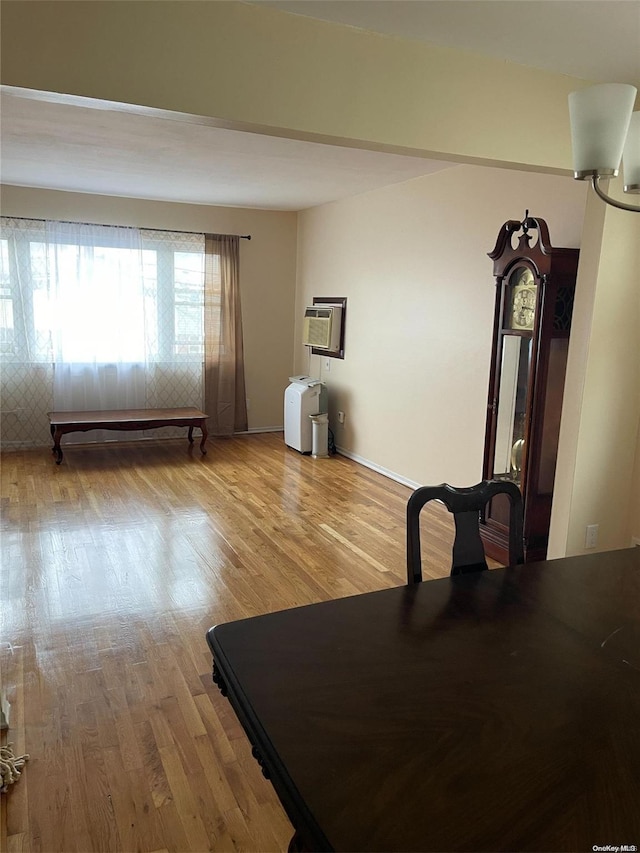 exercise area with a wall mounted air conditioner and hardwood / wood-style flooring