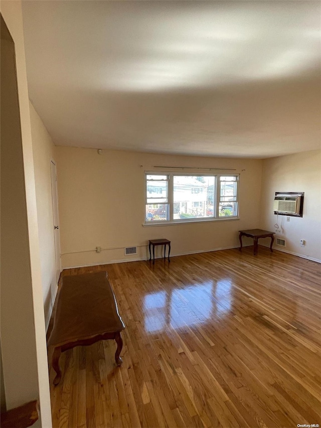 empty room featuring a wall unit AC and hardwood / wood-style flooring