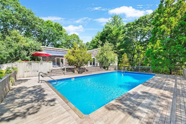 view of pool featuring a patio and a wooden deck