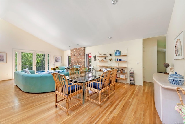 dining room featuring light wood-type flooring and high vaulted ceiling