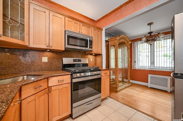 kitchen with radiator, stainless steel appliances, a notable chandelier, light hardwood / wood-style floors, and ornamental molding