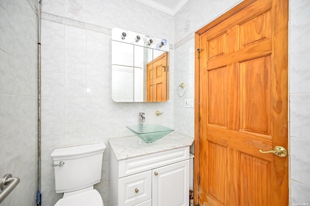 bathroom with vanity, toilet, tile walls, and crown molding