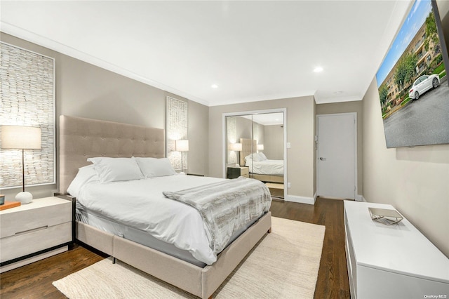 bedroom featuring crown molding, a closet, and dark wood-type flooring