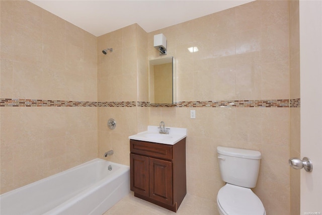 full bathroom with toilet, vanity, tile walls, tile patterned flooring, and tiled shower / bath combo