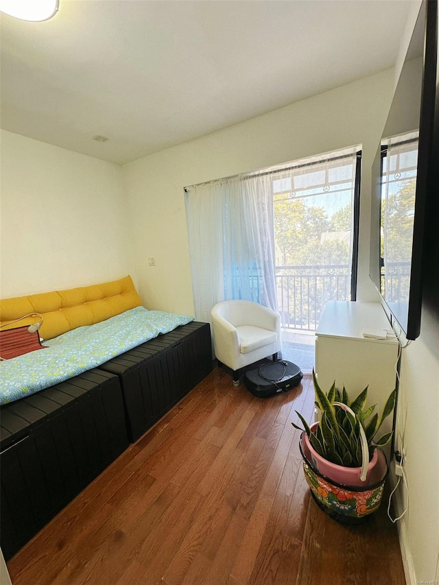 bedroom with hardwood / wood-style floors and access to outside