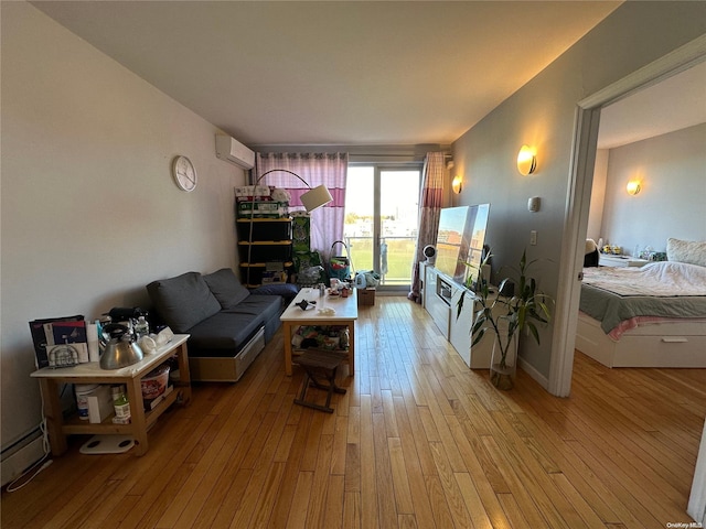 living room featuring a wall mounted air conditioner, light hardwood / wood-style flooring, and a baseboard heating unit