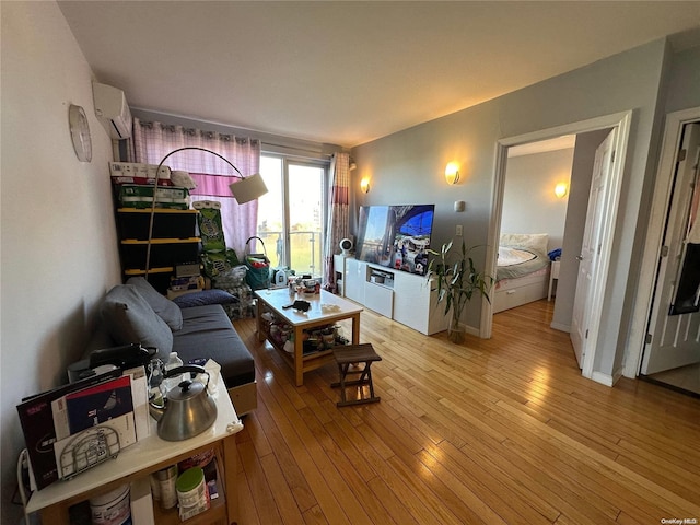 living room featuring a wall unit AC and light hardwood / wood-style flooring