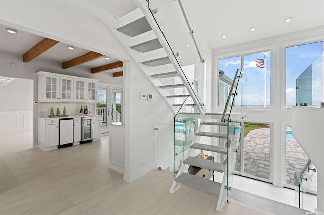 stairway with indoor bar, beverage cooler, and a healthy amount of sunlight