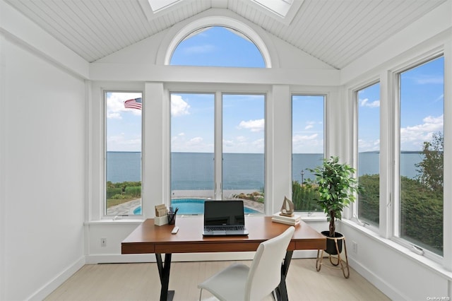 office area featuring a water view, light hardwood / wood-style floors, and vaulted ceiling with skylight