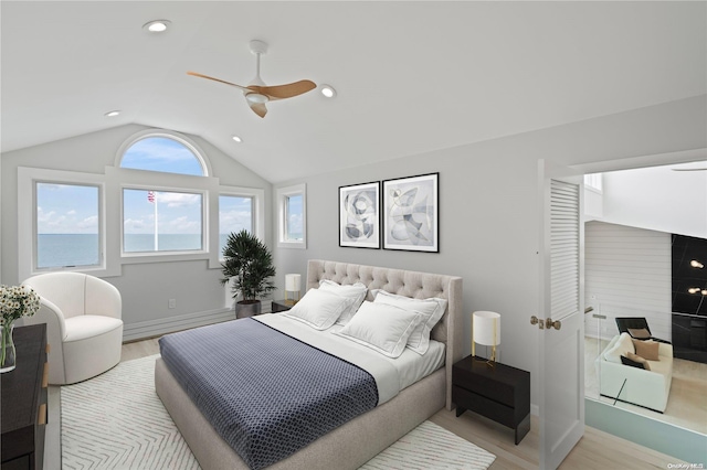 bedroom with ceiling fan, a water view, vaulted ceiling, and light wood-type flooring