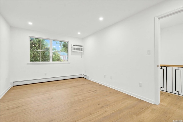 unfurnished room with a wall unit AC, a baseboard radiator, and light wood-type flooring