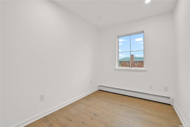 empty room featuring light hardwood / wood-style flooring and a baseboard radiator