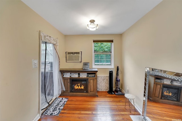 interior space with hardwood / wood-style floors and an AC wall unit